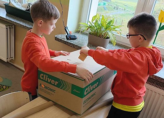 uczniowie oklejają papierem kartony