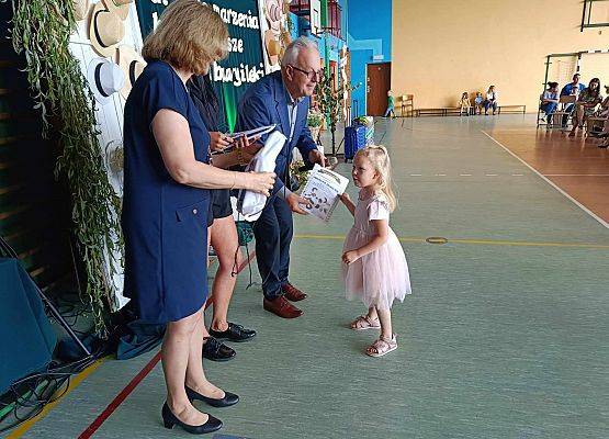 dyrektor wręcza dziewczynce dyplom