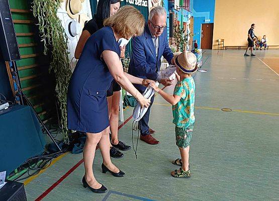 dyrektor wręcza chłopczykowi dyplom