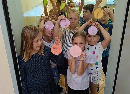 uczniowie trzymają wycięte z papieru kropki