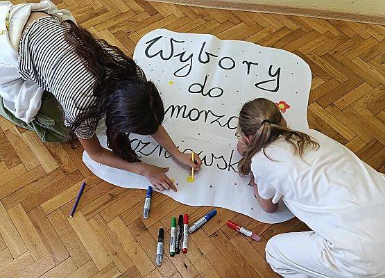 dziewczynki wykonują plakat informacyjny