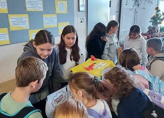 uczniowie przy stoliku z żartami