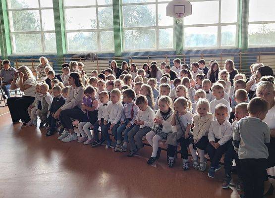 dzieci siedzą na ławkach