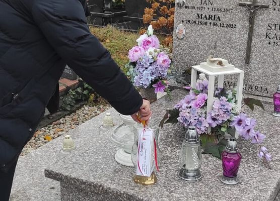 dyrektor szkoły ustawia znicz