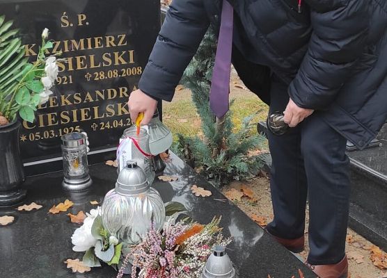 dyrektor szkoły zapala znicz