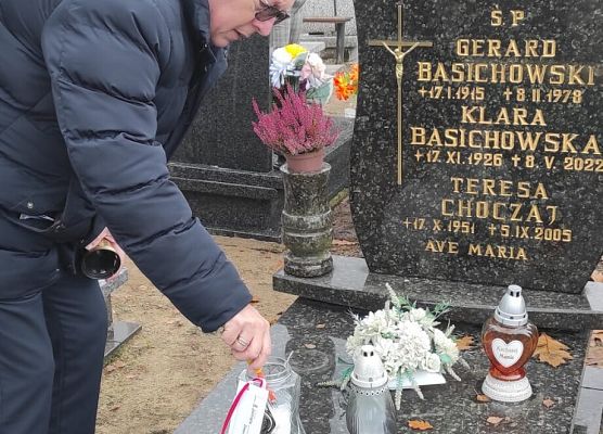 dyrektor szkoły zapala znicz