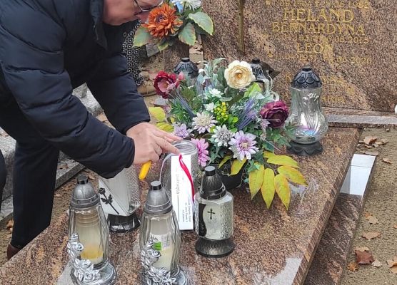 dyrektor szkoły zapala znicz