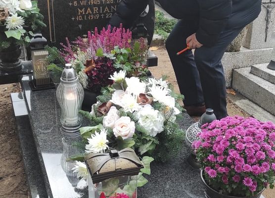 dyrektor szkoły zapala znicz