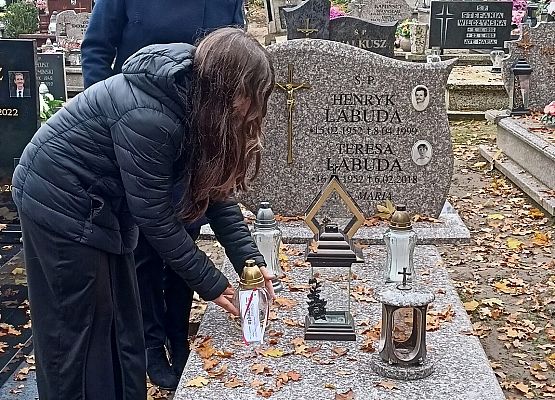 pani wicedyrektor z uczennicą ustawiają znicze