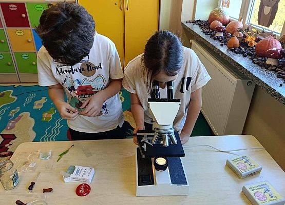 uczennica patrzy przez mikroskop