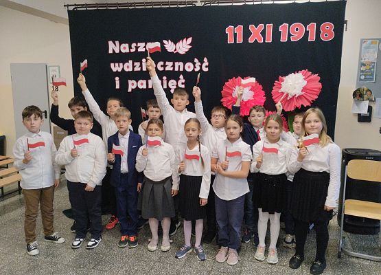 uczniowie trzymają flagi