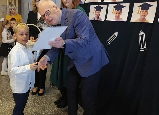 dyrektor wręcza uczniowi dyplom