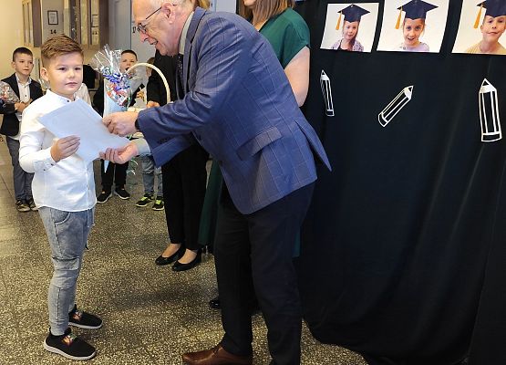 dyrektor wręcza uczniowi dyplom