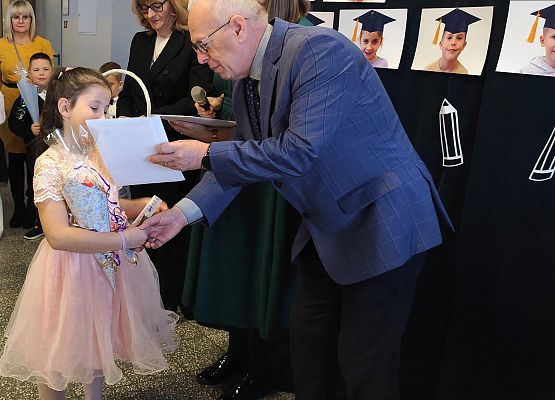 dyrektor wręcza uczennicy dyplom