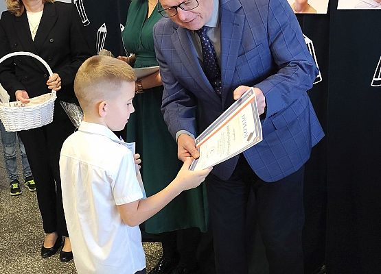 dyrektor wręcza uczniowi dyplom