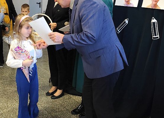 dyrektor wręcza uczennicy  dyplom