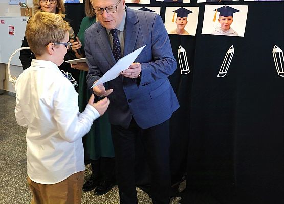 dyrektor wręcza uczniowi dyplom