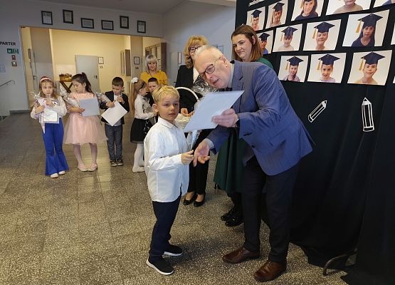 dyrektor wręcza uczennicy dyplom