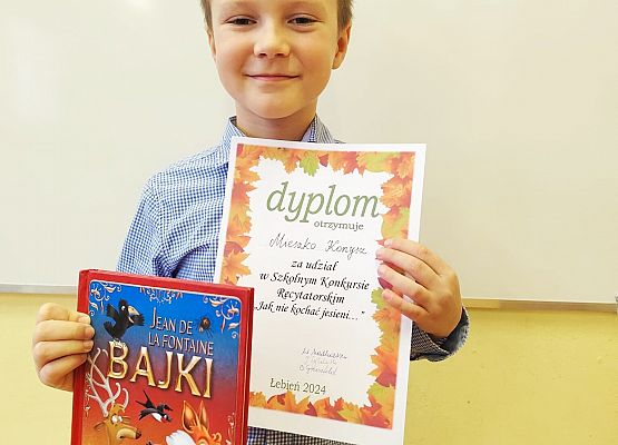 uczeń prezentuje dyplom i nagrodę