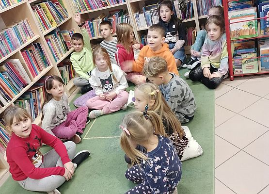 dzieci siedzą na dywanie