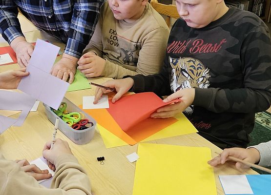 nauczycielka objaśnia jak wykonać ozdobę