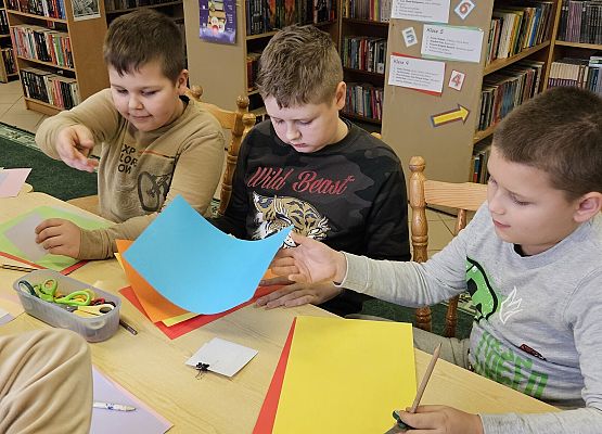 chłopcy wycinają ozdoby z kolorowego papieru