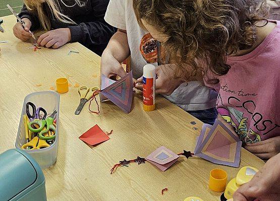 dzieci wykonują ozdoby choinkowe