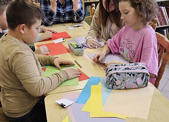 nauczycielka objaśnia dzieciom, jak wykonać pająka