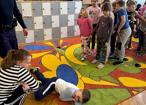 dzieci wykonują zadania z udzielania pierwszej pomocy