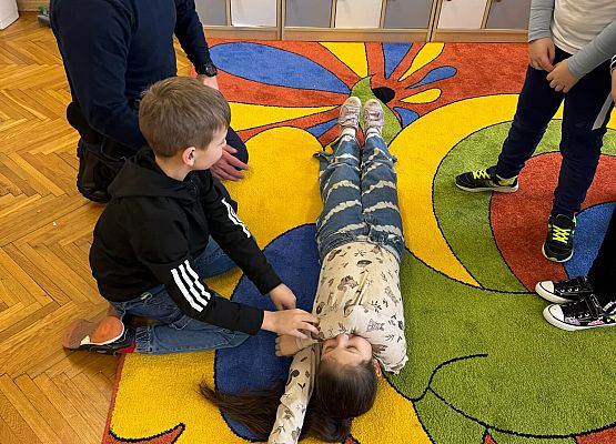 dzieci wykonują zadania z udzielania pierwszej pomocy