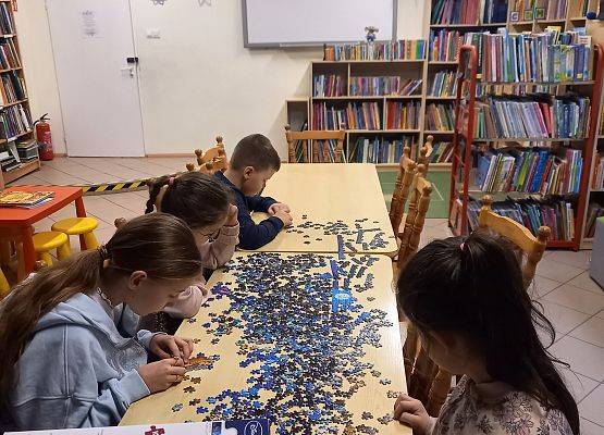 uczniowie układają puzzle