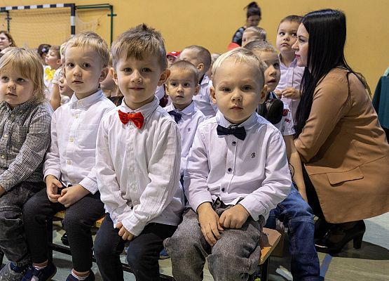 dzieci siedzą na ławeczkach