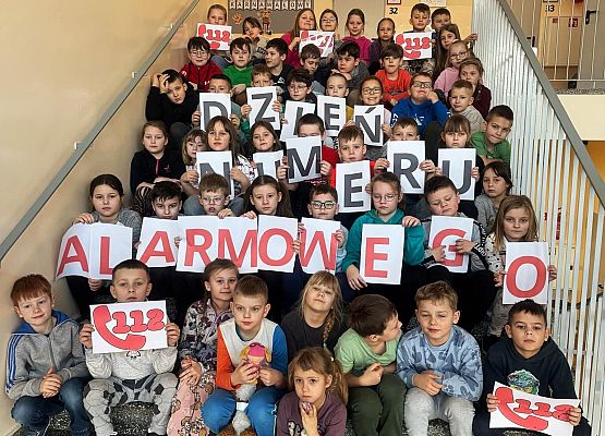 uczniowie z napisem dzień numeru alarmowego