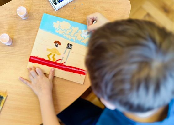 chłopiec maluje na drewnie