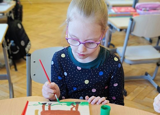 dziewczynka maluje na drewnie