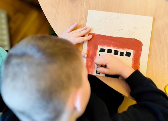 chłopiec maluje na drewnie