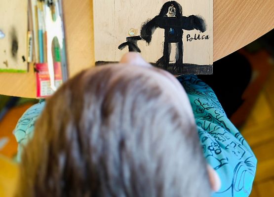 chłopiec maluje na drewnie