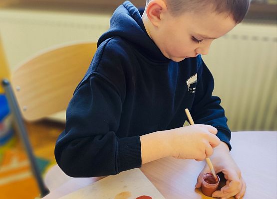 chłopiec maluje na drewnie