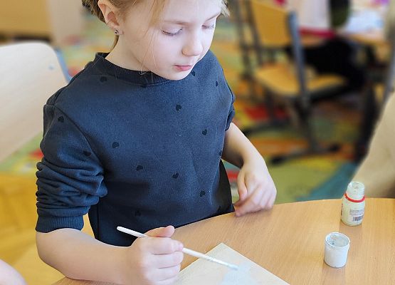 dziewczynka maluje na drewnie