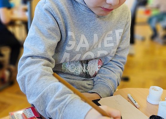 chłopiec maluje na drewnie