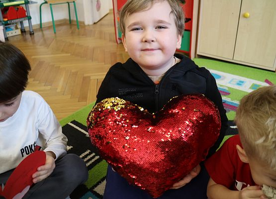 chłopiec trzyma poduszkę w kształcie serca