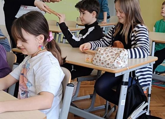 Nauczycielka rozdaje nagrody uczniom