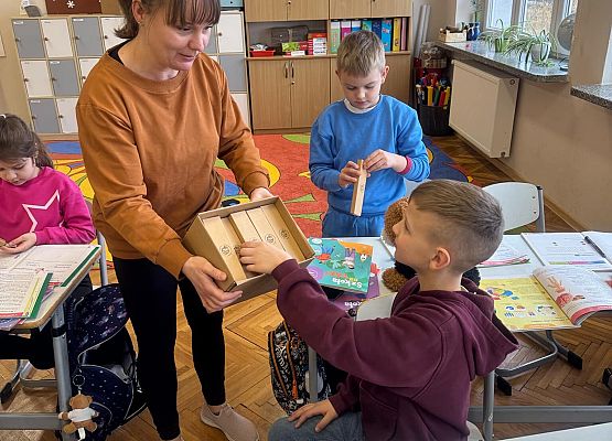 Nauczycielka rozdaje nagrody uczniom