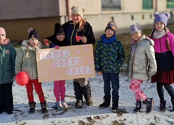 nauczycielka z uczniami prezentuje plakat  "Podaj dobro"