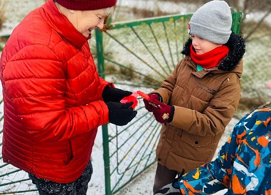 uczniowie wręczają serduszko
