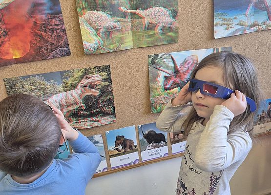 dzieci oglądają zdjęcia dinozaurów