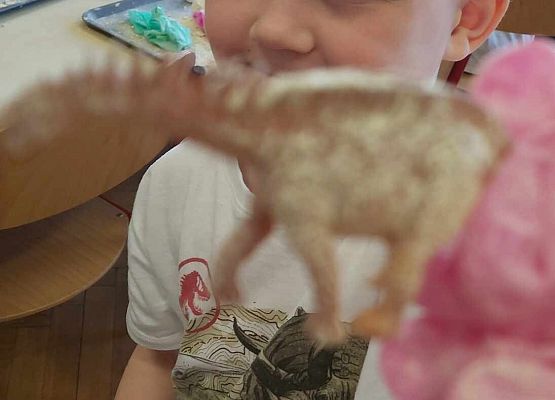 Chłopiec pokazuje dinozaura