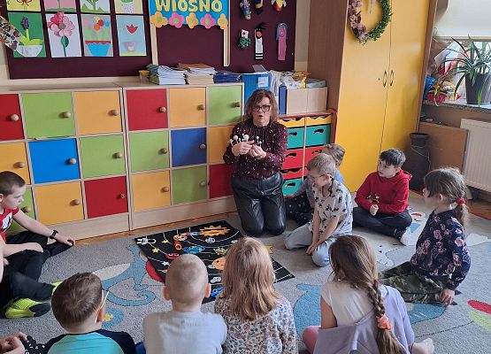 nauczycielka prezentuje dzieciom makietę układu słonecznego