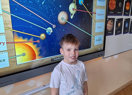 chłopiec wykonuje zadanie przy tablicy multimedialnej