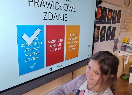 dziewczynka wykonuje zadanie na tablicy